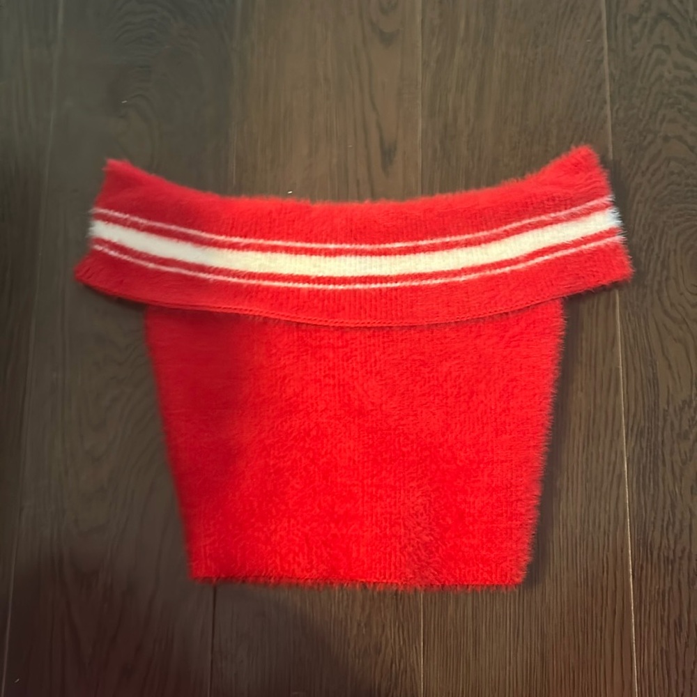 A small red crop off sleeve sweater